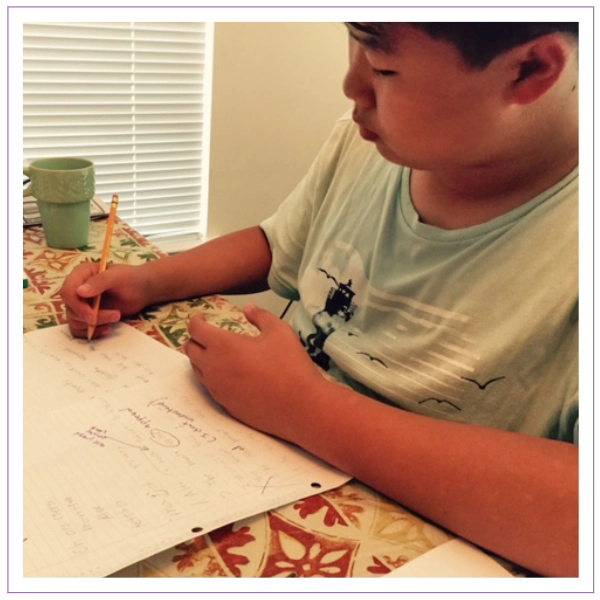 boy writing on paper